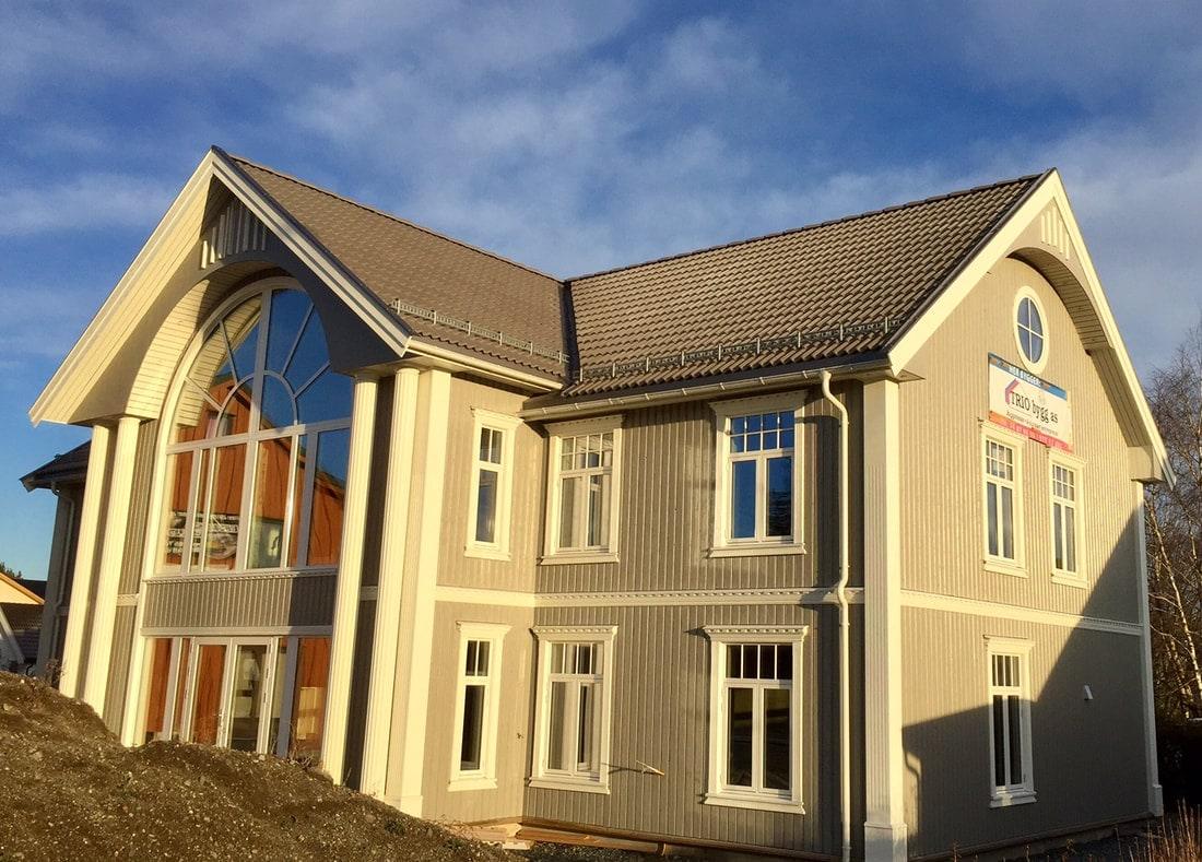 Gult hus med stort buet vindu i gavlen